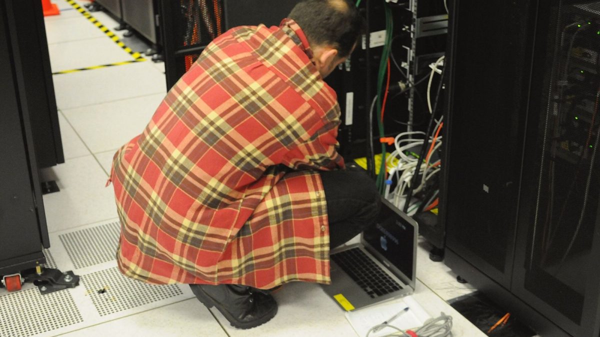 Archieffoto van een technicus met een laptop bij een serverkast; geen beeld van een Belgisch incident